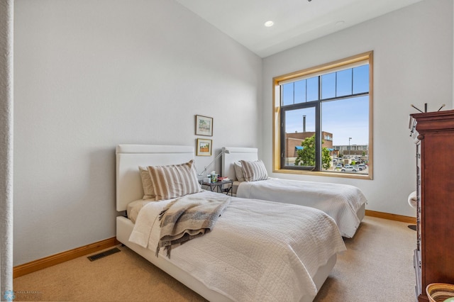 bedroom with light colored carpet and lofted ceiling