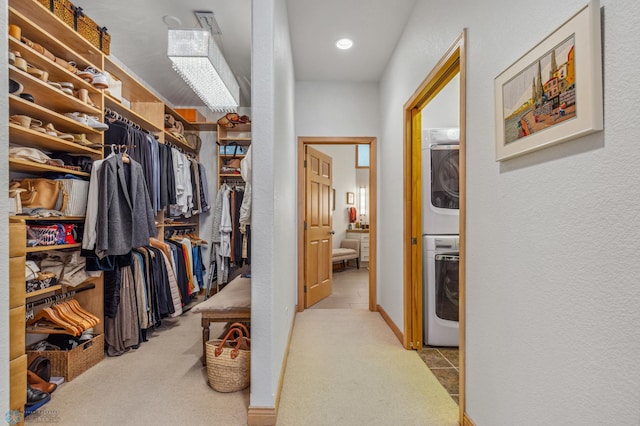 spacious closet with stacked washing maching and dryer and light colored carpet