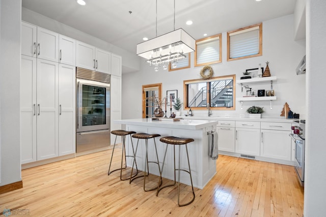 kitchen featuring white cabinets, a breakfast bar, decorative light fixtures, and a kitchen island