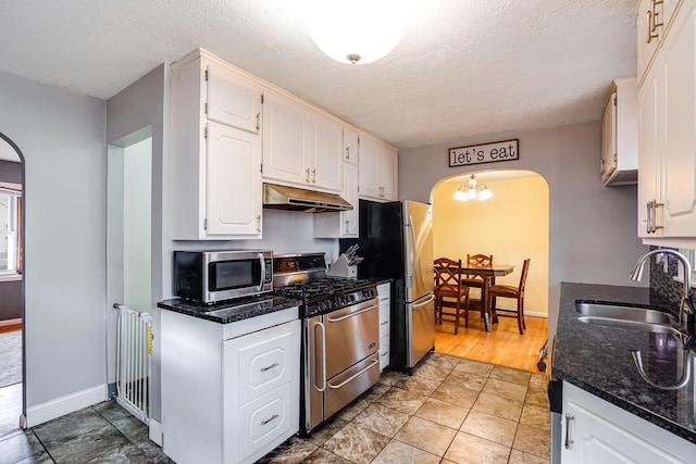 kitchen with a textured ceiling, sink, white cabinetry, and stainless steel appliances