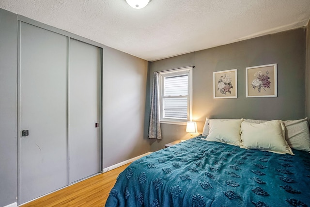 bedroom featuring a closet, a textured ceiling, and hardwood / wood-style flooring