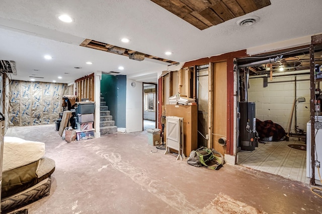 basement with water heater and a textured ceiling