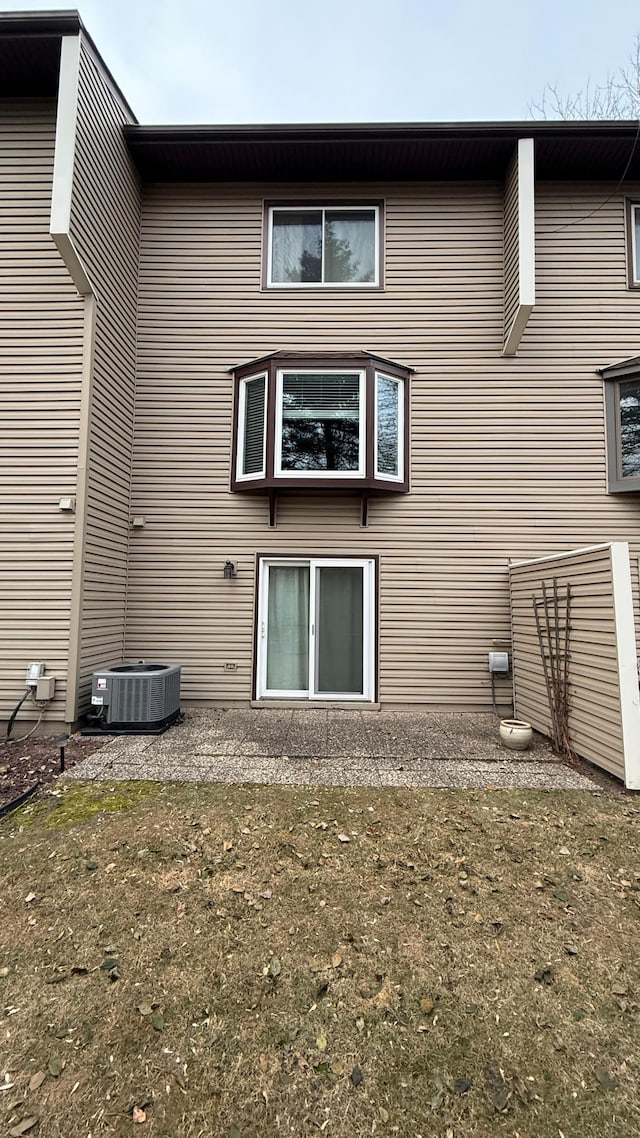 back of house with a lawn and cooling unit