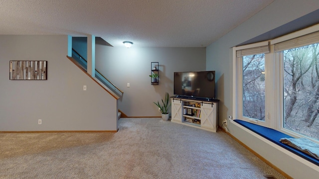 unfurnished living room with light colored carpet and a textured ceiling