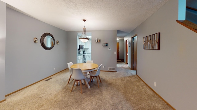 dining space with light carpet and a textured ceiling