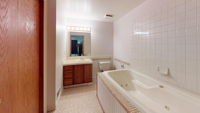 bathroom featuring a washtub, tile patterned floors, vanity, and toilet