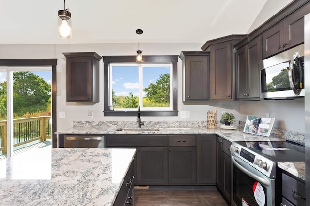 kitchen featuring sink, decorative light fixtures, stainless steel appliances, and light stone countertops