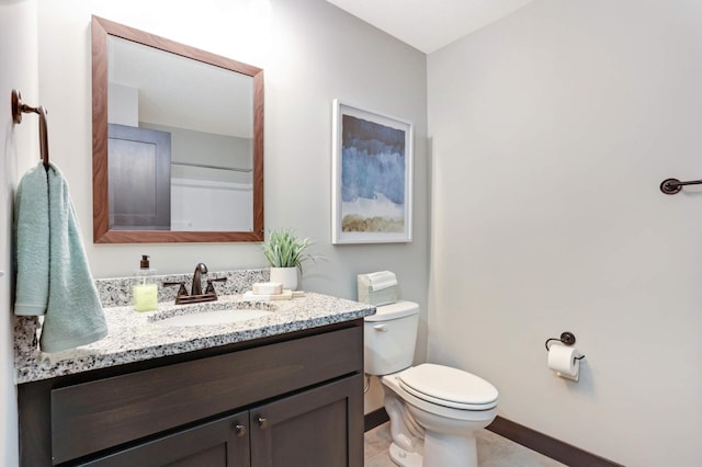 bathroom with tile patterned flooring, vanity, and toilet