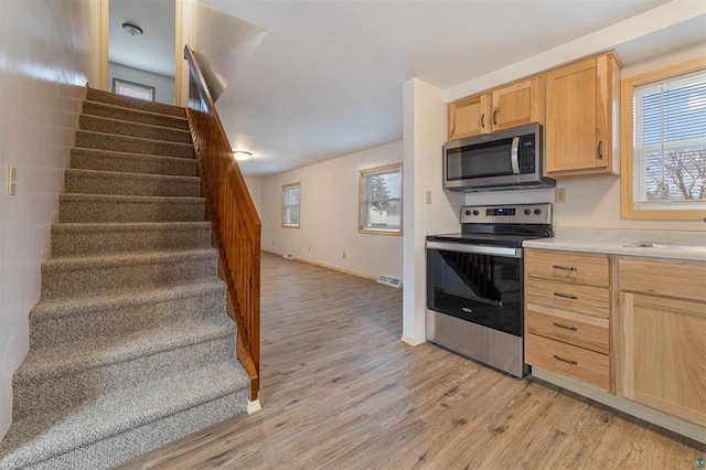 kitchen featuring light hardwood / wood-style floors, sink, stainless steel appliances, and light brown cabinets