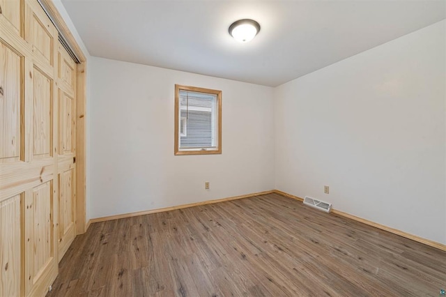 unfurnished bedroom featuring hardwood / wood-style floors and a closet