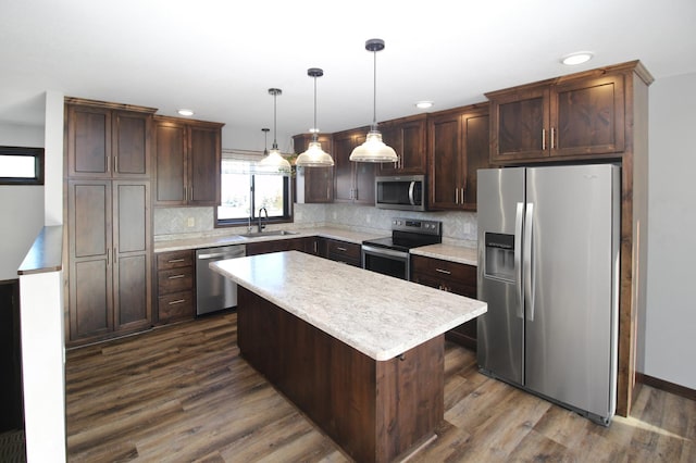 kitchen featuring sink, hanging light fixtures, stainless steel appliances, dark hardwood / wood-style floors, and a kitchen island