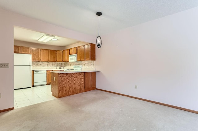 kitchen featuring kitchen peninsula, backsplash, white appliances, light colored carpet, and hanging light fixtures