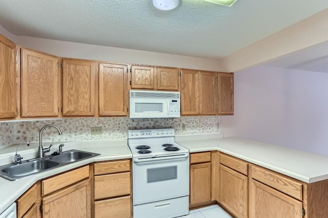 kitchen with sink, kitchen peninsula, a textured ceiling, white appliances, and light tile patterned floors