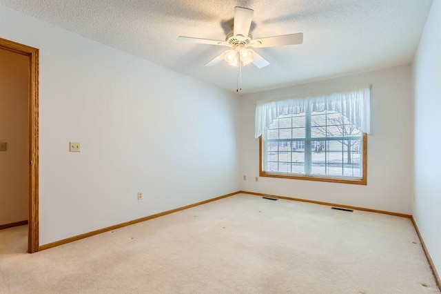 carpeted spare room featuring ceiling fan and a textured ceiling