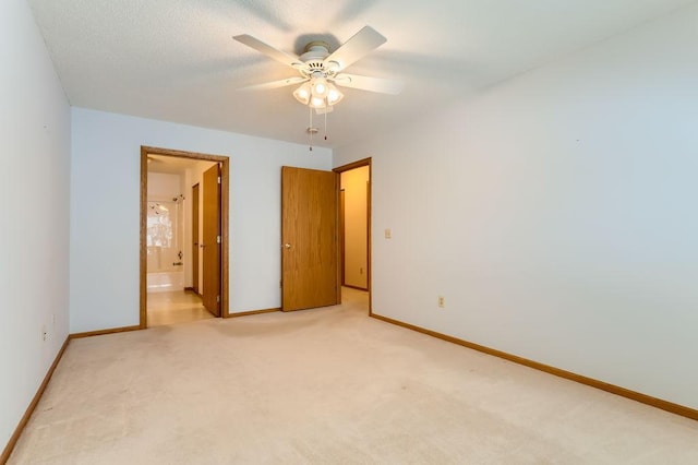 unfurnished bedroom with ceiling fan, light carpet, and ensuite bath