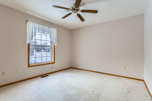 carpeted spare room with ceiling fan and a textured ceiling