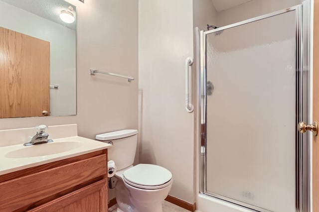 bathroom with vanity, toilet, and a shower with door