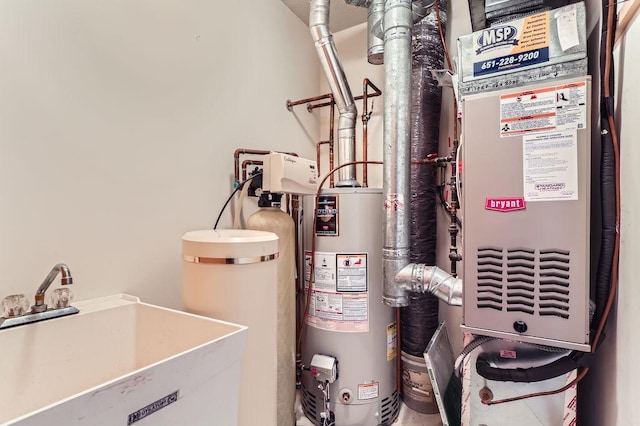 utility room featuring gas water heater and sink