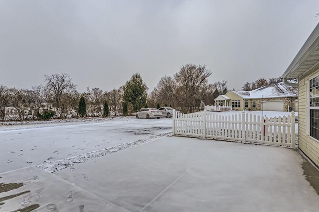 snow covered patio with a garage