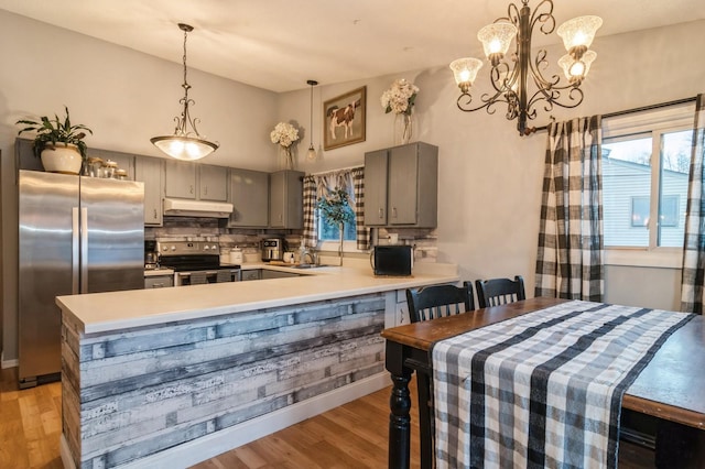 dining space featuring a chandelier, sink, light hardwood / wood-style floors, and a high ceiling