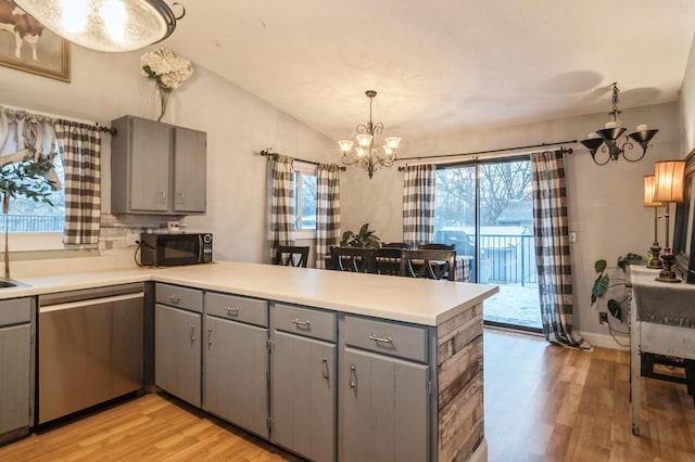 kitchen with kitchen peninsula, pendant lighting, dishwasher, a chandelier, and lofted ceiling