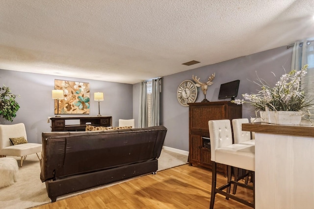 living room with wood-type flooring and a textured ceiling