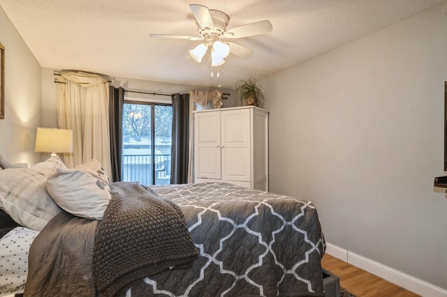 bedroom with ceiling fan, access to exterior, wood-type flooring, and a textured ceiling