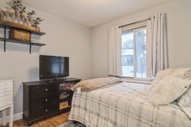 bedroom featuring a textured ceiling and light hardwood / wood-style flooring