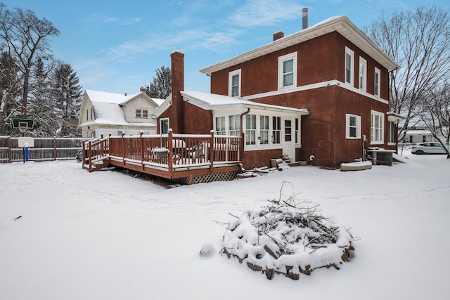 snow covered property featuring central AC and a deck