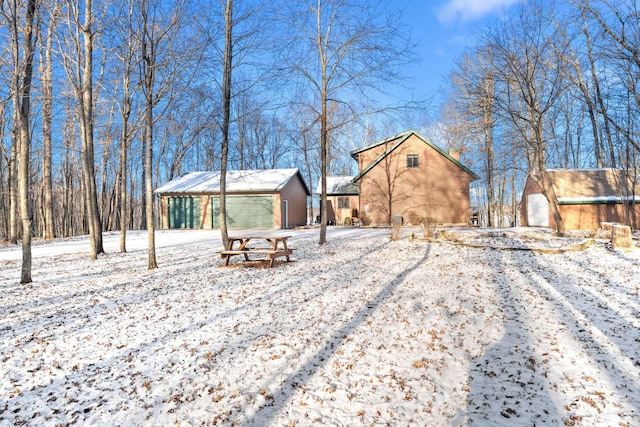 yard covered in snow with an outdoor structure and a garage