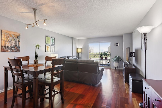 dining space with dark wood-type flooring and a textured ceiling