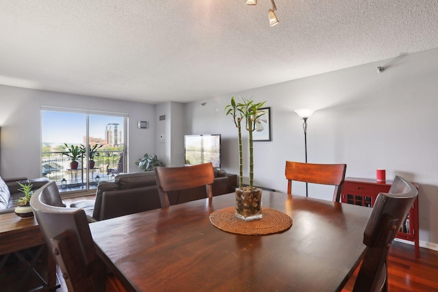 dining room featuring dark hardwood / wood-style floors and a textured ceiling