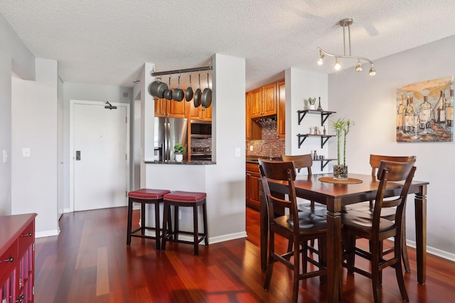 dining space with dark hardwood / wood-style flooring and a textured ceiling