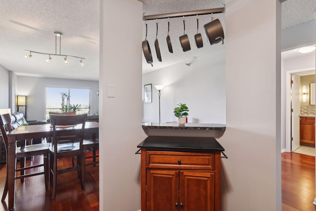 interior space featuring a textured ceiling, decorative backsplash, and dark hardwood / wood-style floors