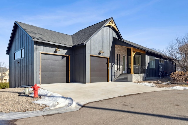 view of front facade featuring board and batten siding, concrete driveway, an attached garage, and a shingled roof