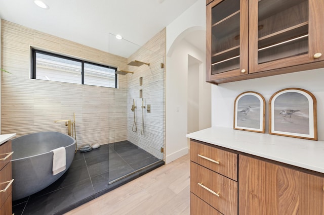 3702 Planting Grn, Stillwater, MN 55082 - full bath with vanity, a walk in shower, a freestanding tub, recessed lighting, and wood finished floors
