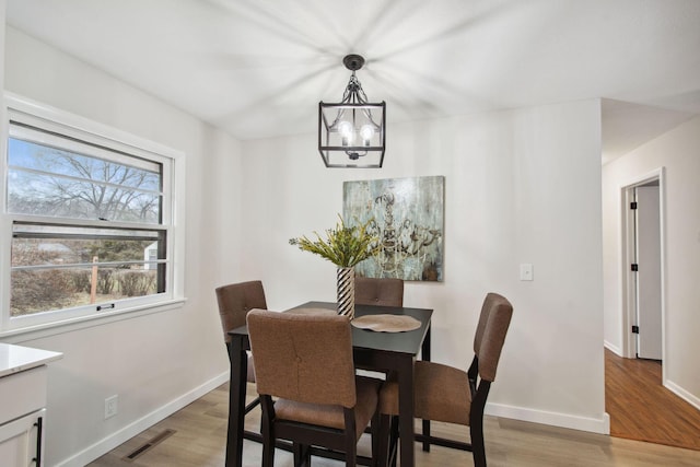 dining space with a chandelier and light hardwood / wood-style flooring