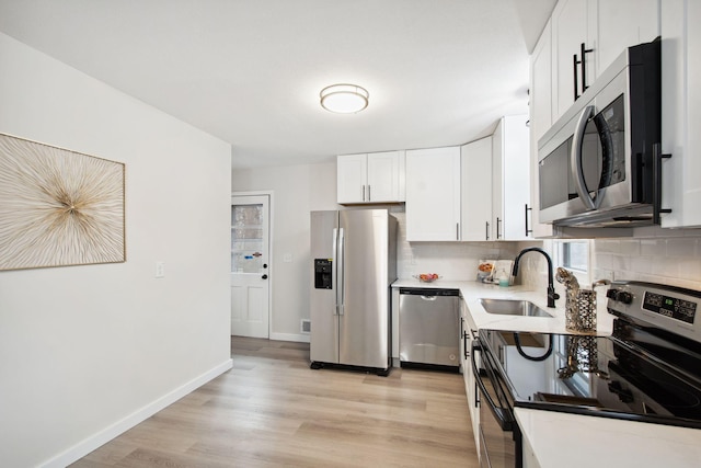 kitchen with white cabinets, appliances with stainless steel finishes, decorative backsplash, and sink