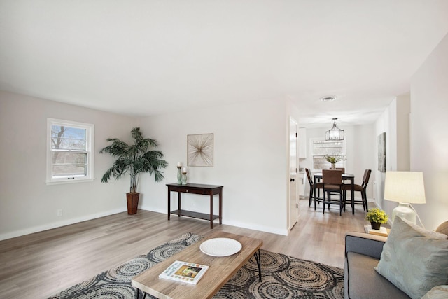 living room featuring a notable chandelier and light hardwood / wood-style flooring