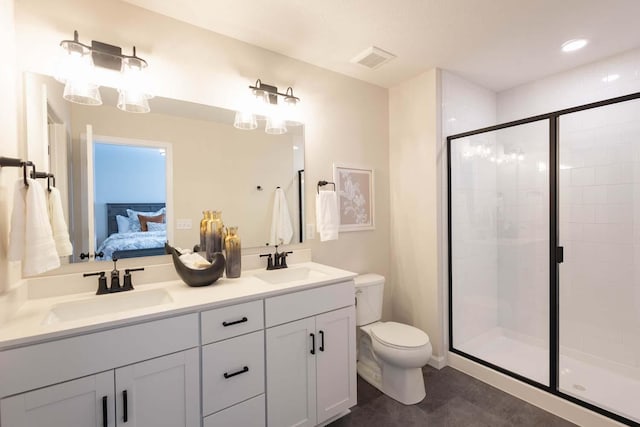 bathroom with vanity, toilet, and a shower with door