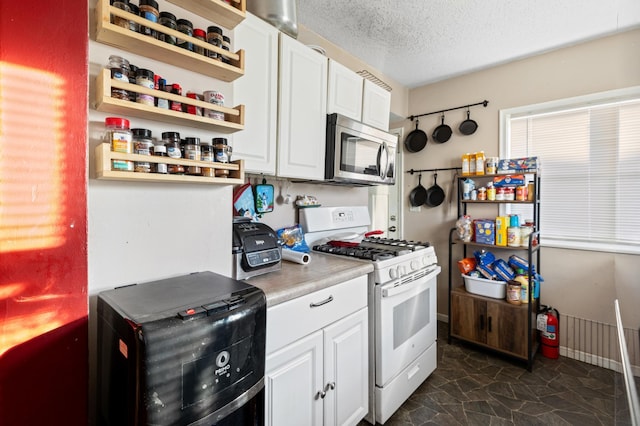 kitchen with white cabinetry, a textured ceiling, and gas range gas stove