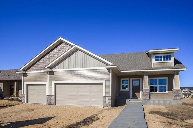 craftsman-style home with stone siding, a garage, a porch, and dirt driveway