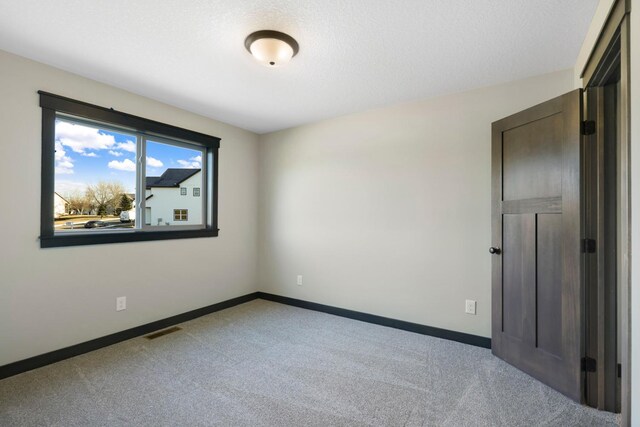 unfurnished room with carpet flooring and baseboards
