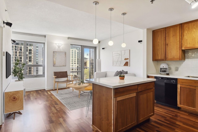 kitchen with a center island, dark wood-type flooring, black dishwasher, tasteful backsplash, and pendant lighting