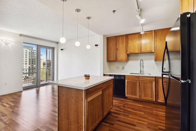 kitchen featuring sink, dark hardwood / wood-style flooring, backsplash, decorative light fixtures, and black appliances