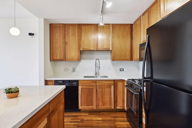 kitchen with dark hardwood / wood-style flooring, tasteful backsplash, sink, black appliances, and decorative light fixtures