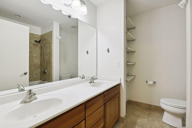 full bathroom with tiled shower / bath, tile patterned floors, vanity, and toilet