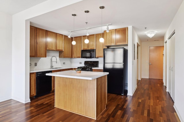 kitchen with sink, dark hardwood / wood-style flooring, decorative light fixtures, a kitchen island, and black appliances