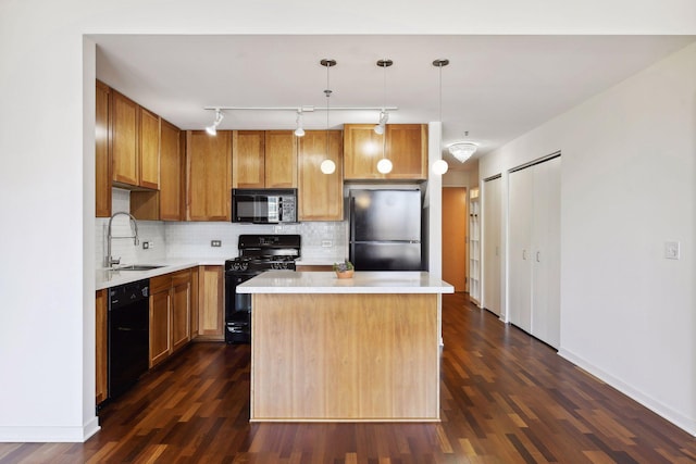 kitchen featuring dark wood-type flooring, sink, black appliances, decorative light fixtures, and a kitchen island