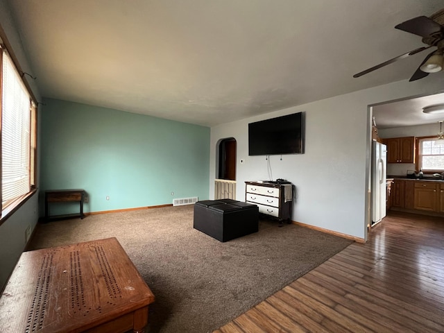 unfurnished living room featuring ceiling fan and dark hardwood / wood-style floors